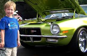 Little boy standing in front of a Z28 car at the Cops & Kids Car Show