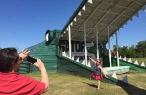 Parent taking a picture of a little girl posing in front of Big Beau at Gator Country Adventure