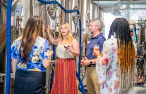 A woman guides a group through a brewery