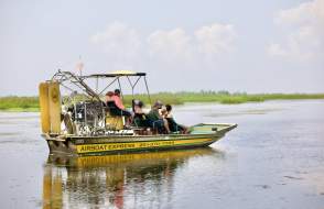 Yellow airboat with passengers in still waters