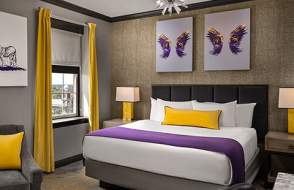 Hotel room bed, two framed artwork of wings above the bed