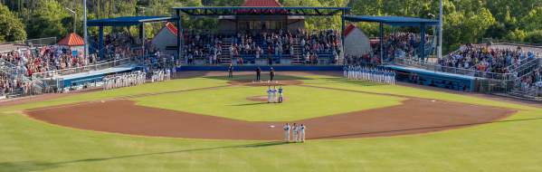 Players and fans standing for national anthem at baseball game