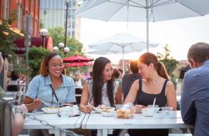 Three people eating outside at Fritas Batidos