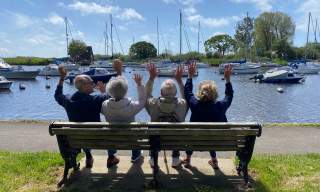 People sat on bench looking out across Christchurch Quay