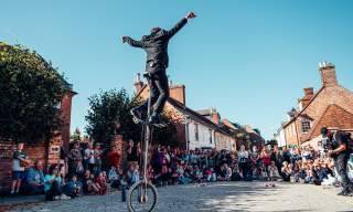 Man on unicycle in front of large crowd