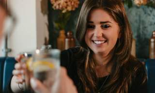 Woman toasting with a drink in a restaurant