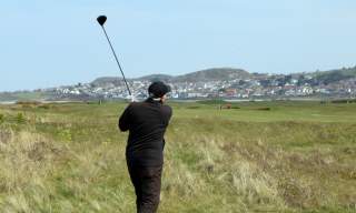 A golfer teeing off at Conwy Golf Club