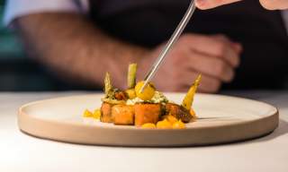 View of a dish being delicately prepared by a chef