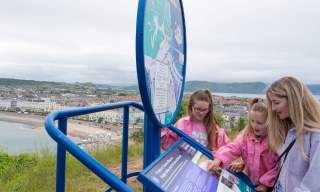 Children looking at one of the signs along the Llandudno Heritage Trail