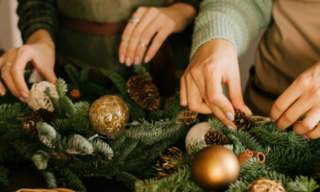 Two people making Christmas wreaths