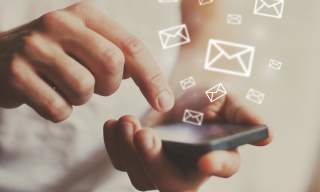 person holding phone with envelopes