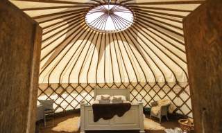 bell tent with a double bed and some chairs