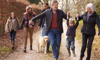 family walking a dog in autumn