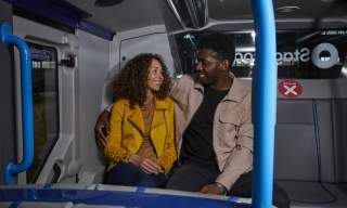 Two people on a stagecoach bus at night