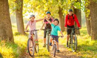 family of four two children at the front cycling on a sunny day