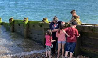 A group of children on a beach with waves coming in