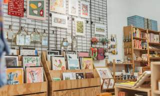 Interior of an Form Studio and studio in Hull displaying art prints, handmade gifts, stationery, books and homeware on wooden shelves and wall grids.