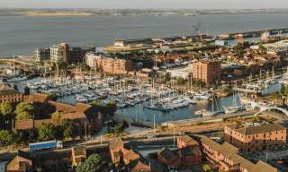 Aerial view of Hull Marina with boats, waterfront buildings, footbridge and the Humber Estuary in the background