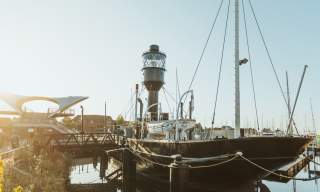 Spurn Lightship moored at Hull Marina on a sunny day with reflections in the water and surrounding waterfront architecture
