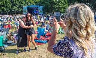 Two women hug and smile for a photo at the Camp Dalfest in Glenarm