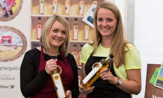 Two ladies holding bottles of Broighter Gold rapeseed oil
