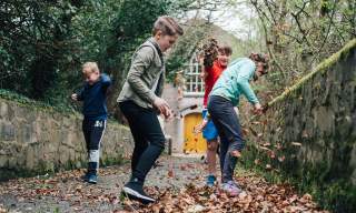 Children playing in the Autumn leaves at the Ulster Folk Museum.