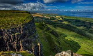 Top of Binevenagh over looking green farmland with Donegal in the distance
