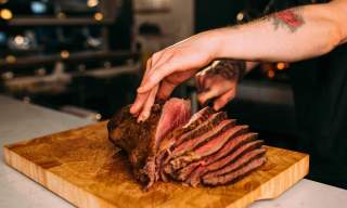 A chef slicing a large piece of beef for Sunday Lunch