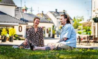 Ett par har piknikk i parken langs gågata