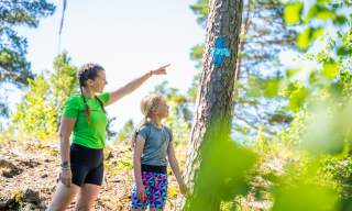 To barn følger blåløype i skogen i Ørje.