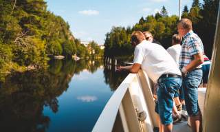 Fire personer står ved relingen på skipet, og ser utover Haldenkanalen