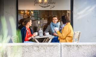 Venninnegjengen sitter sammen på kafé