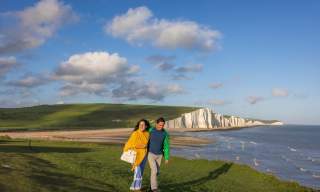 A man and woman walk along the cliffs at Seven Sisters, Sussex