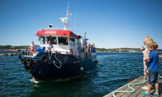 To barn står og venter på at MS Bragdøya legger til kai
