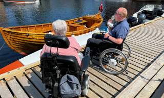To rullestolbrukere spiser is på brygga