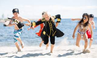 Happy children dressed as pirates on a beach in Kristiansand