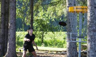 gutt som spiller frisbeegolf