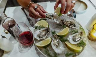 Hender som skviser sitron på østers