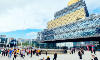 A group of people standing in Centenary Square in front of the Library of Birmingham