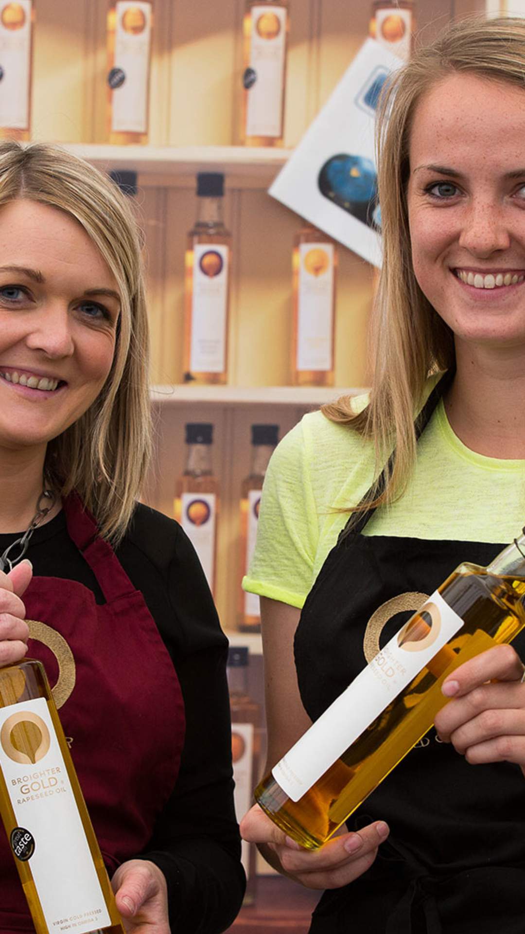 Two ladies holding bottles of Broighter Gold rapeseed oil