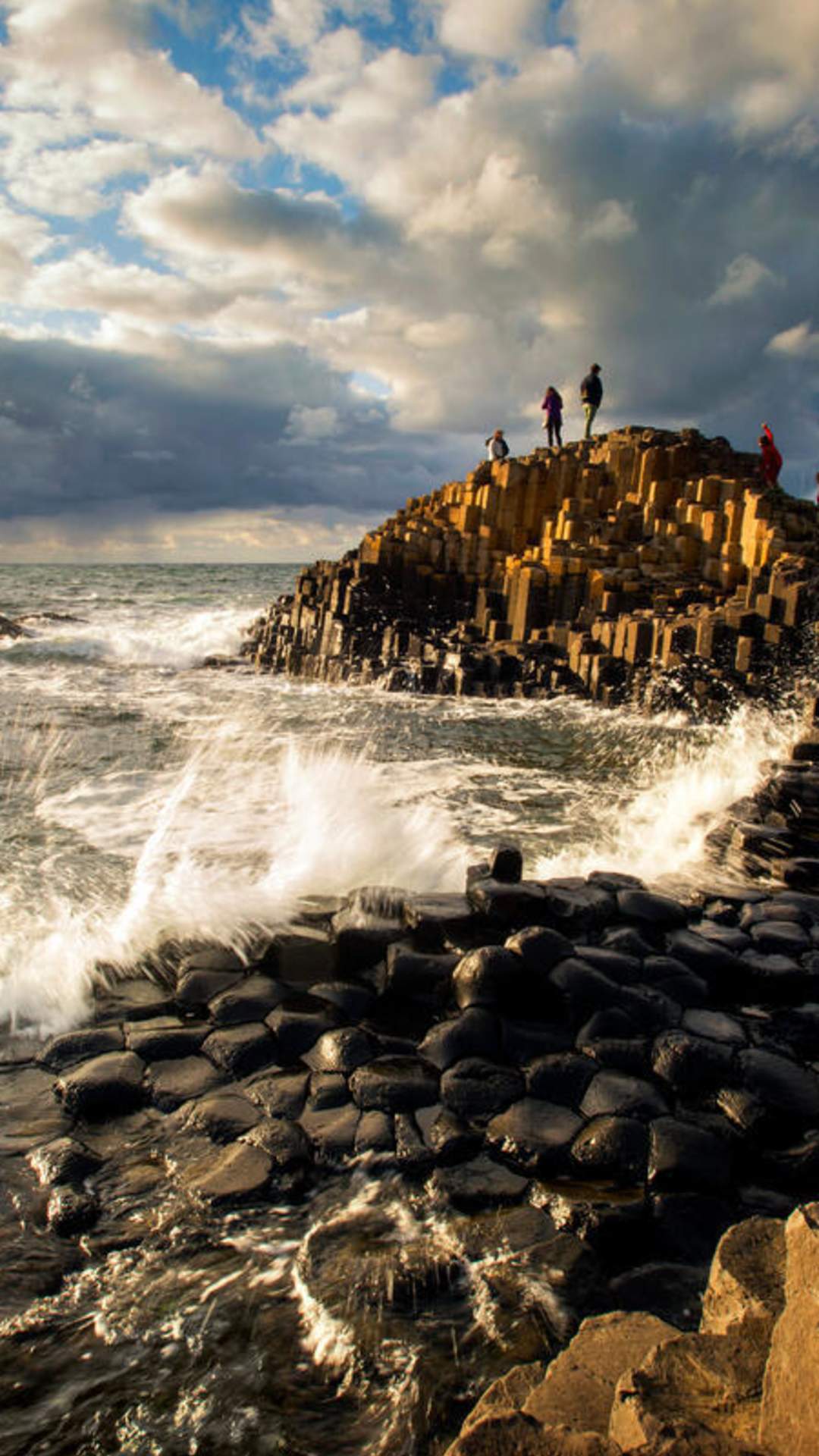 A couple in the distance standing on the Giant's Causeway.