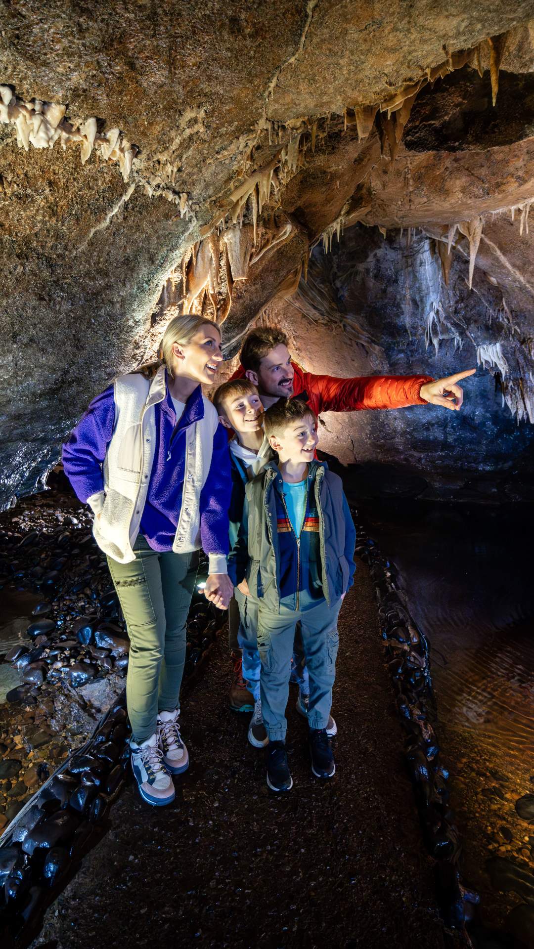 Family enjoying a tour of the underground caves at Marble Arch Caves, looking at stalactites.