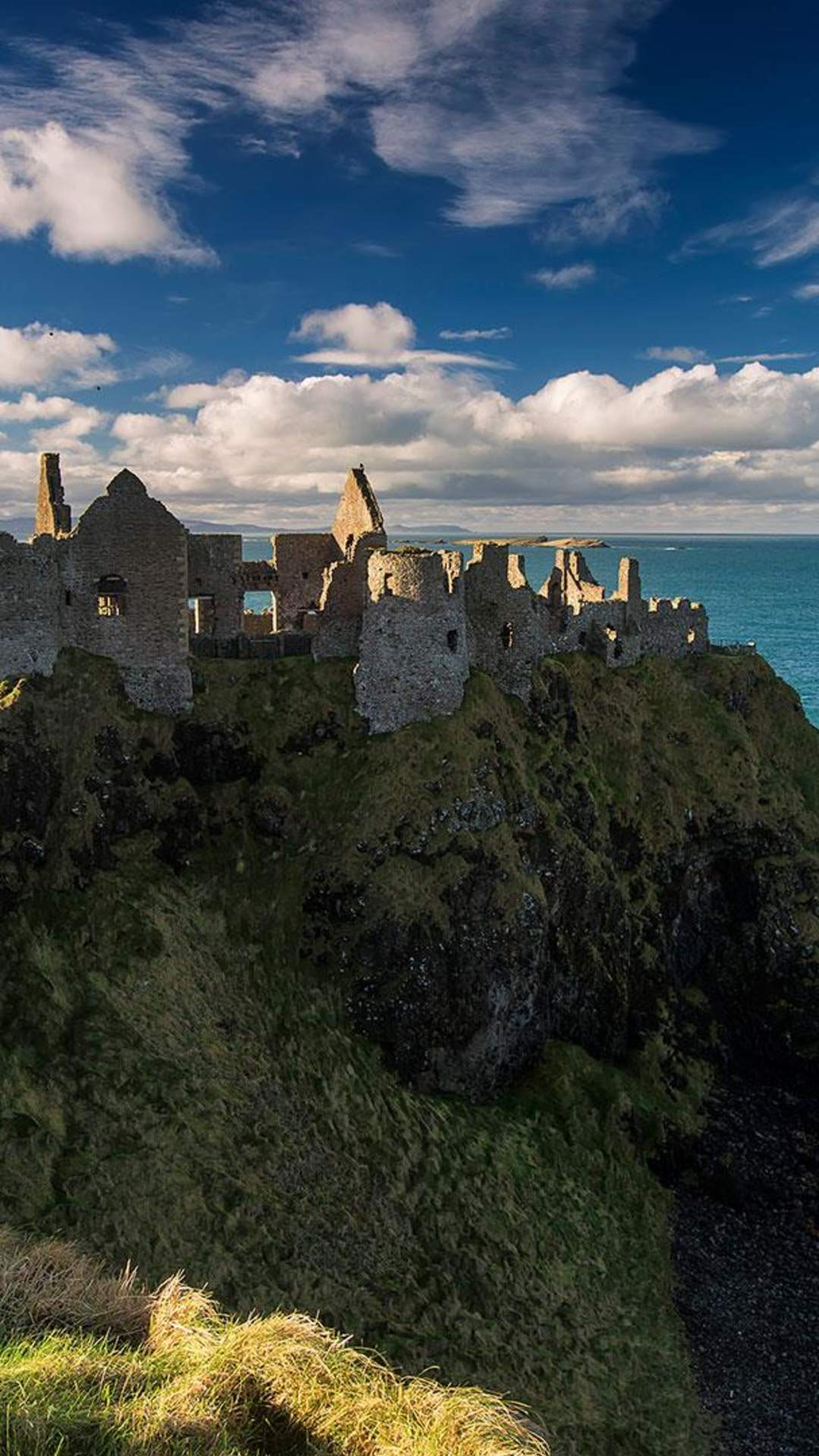 Medieval Dunluce Castle with blue skies.