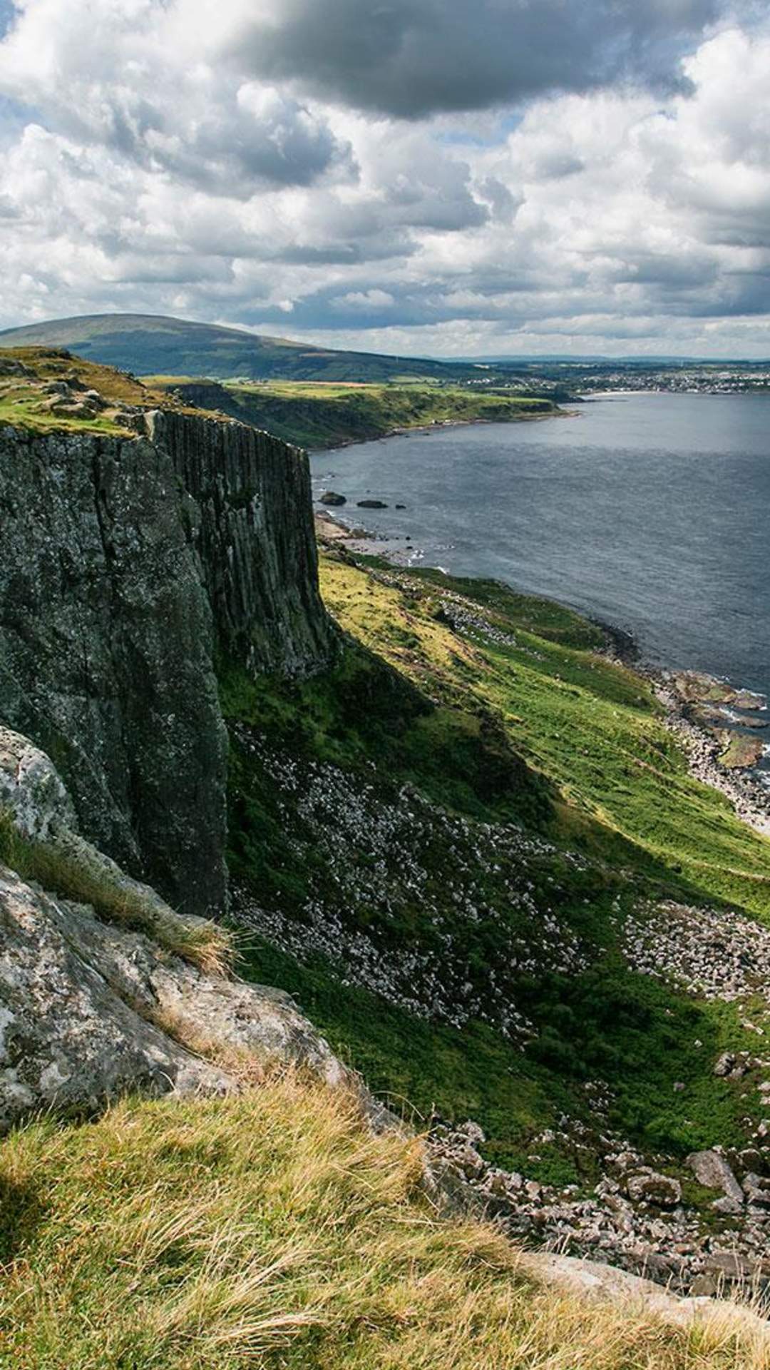 Cliff view from Fair head over looking blue still water and blue skies