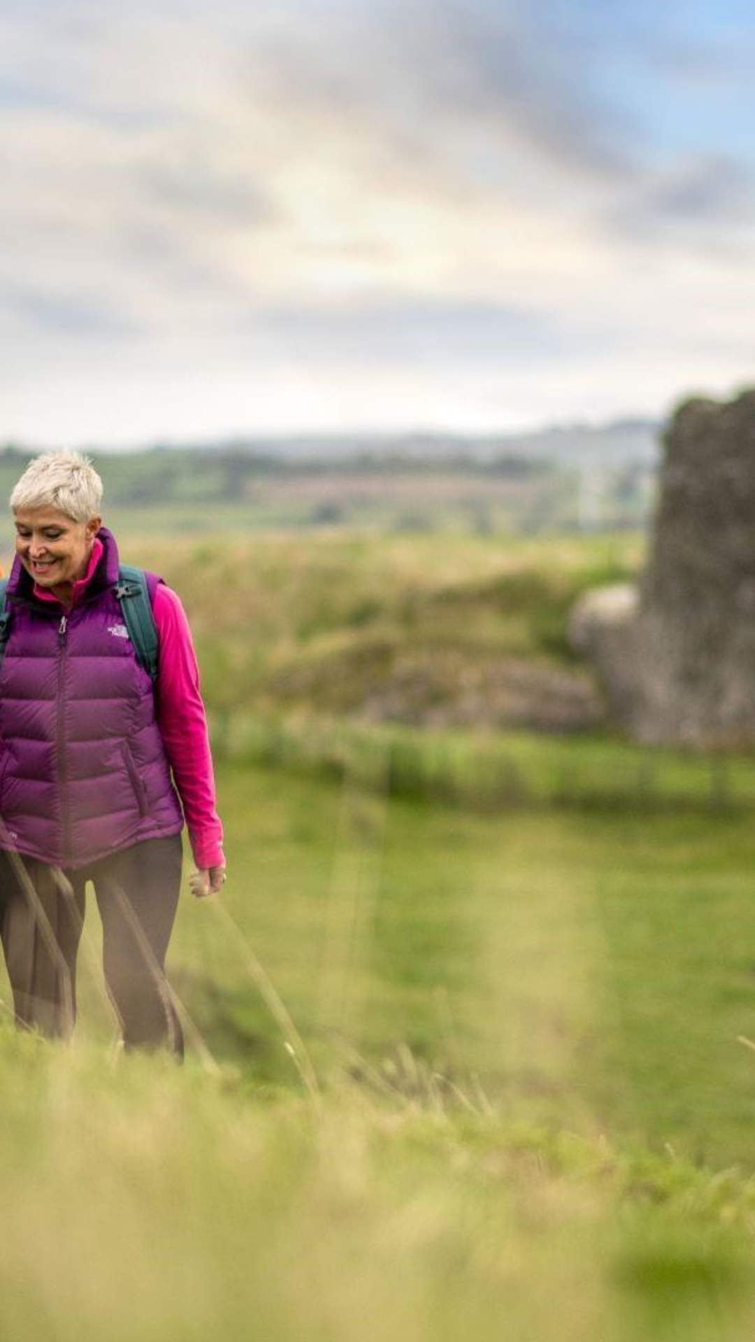 A couple enjoying a walk around the site of Harry Avery's castle with ruins in the background