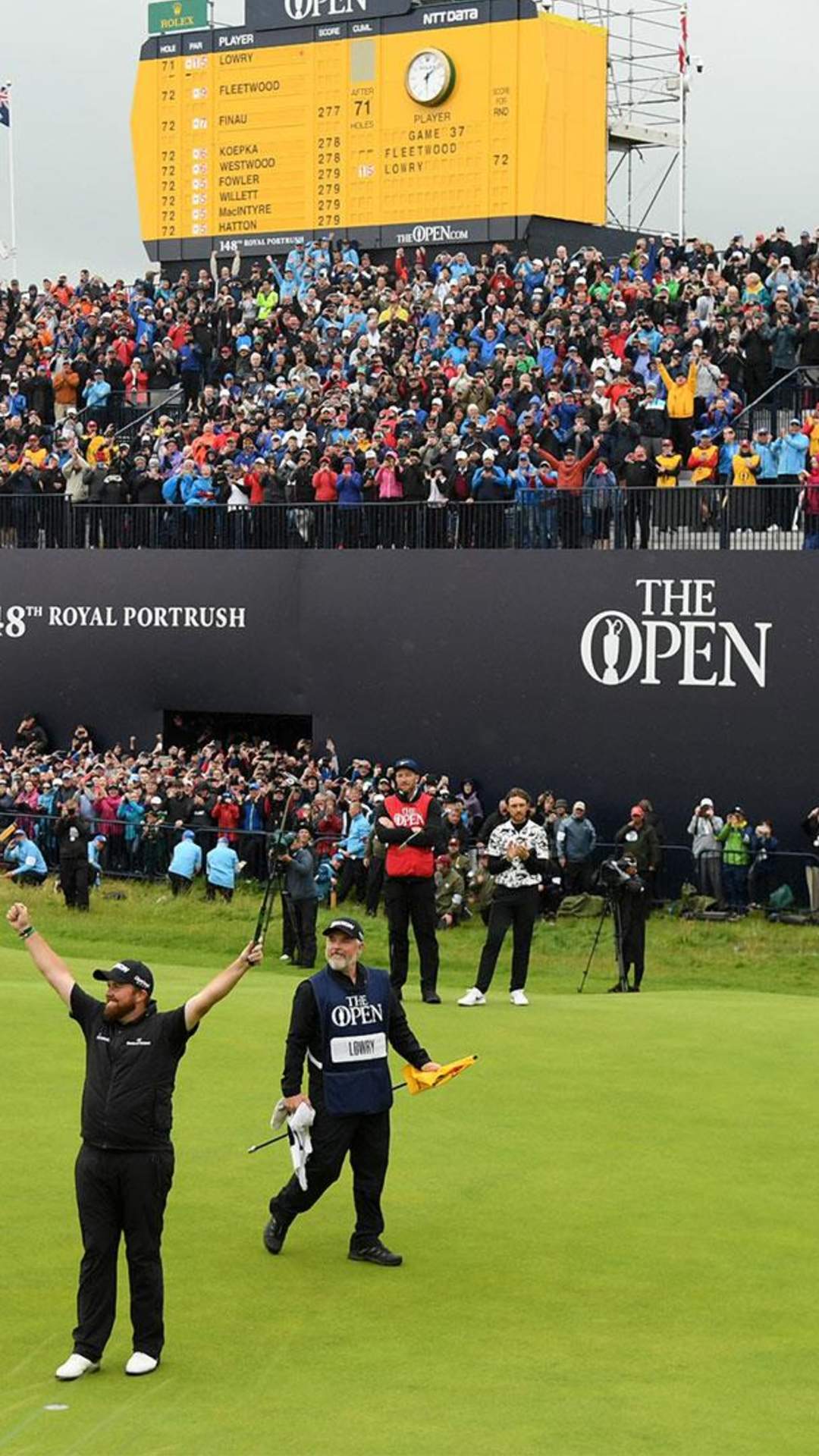 Golfer Shane Lowry celebrating his British Open win on the 18th green in front of a huge crowd
