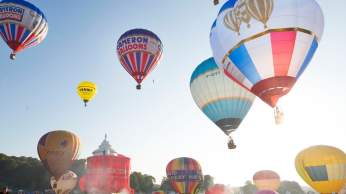 A group of balloons lifting off in a mass ascent at Bristol International Balloon Fiesta - credit Paul Box
