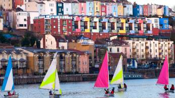 A view of small sailboats on Bristol's Harbourside with the colourful houses of Cliftonwood in the background - credit Paul Box