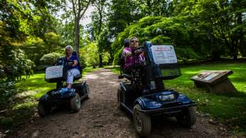 Two mobility scooter users on a path at Westonbirt Arboretum - credit Johnny Hathaway