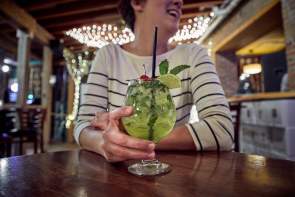 Woman holding cocktail in bar